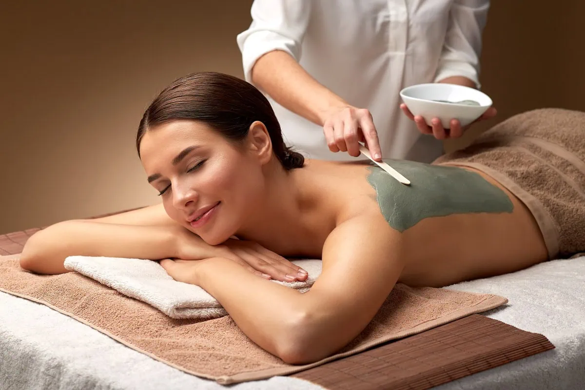 Woman receiving green mud body treatment in Oklahoma City, OK