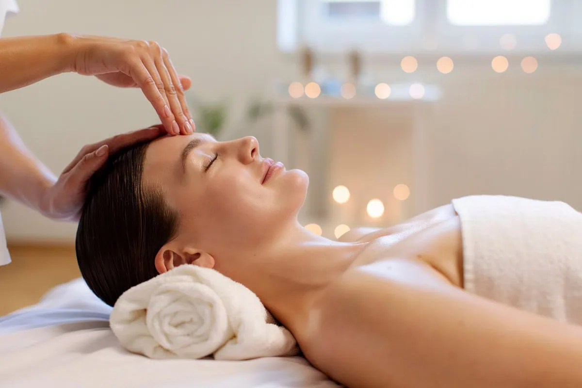 Woman receiving relaxing facial massage in a wellness spa.