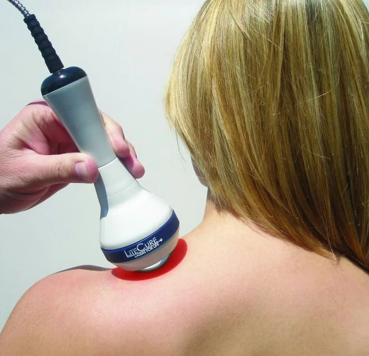 Aesthetic professional using body contouring device on shoulder.