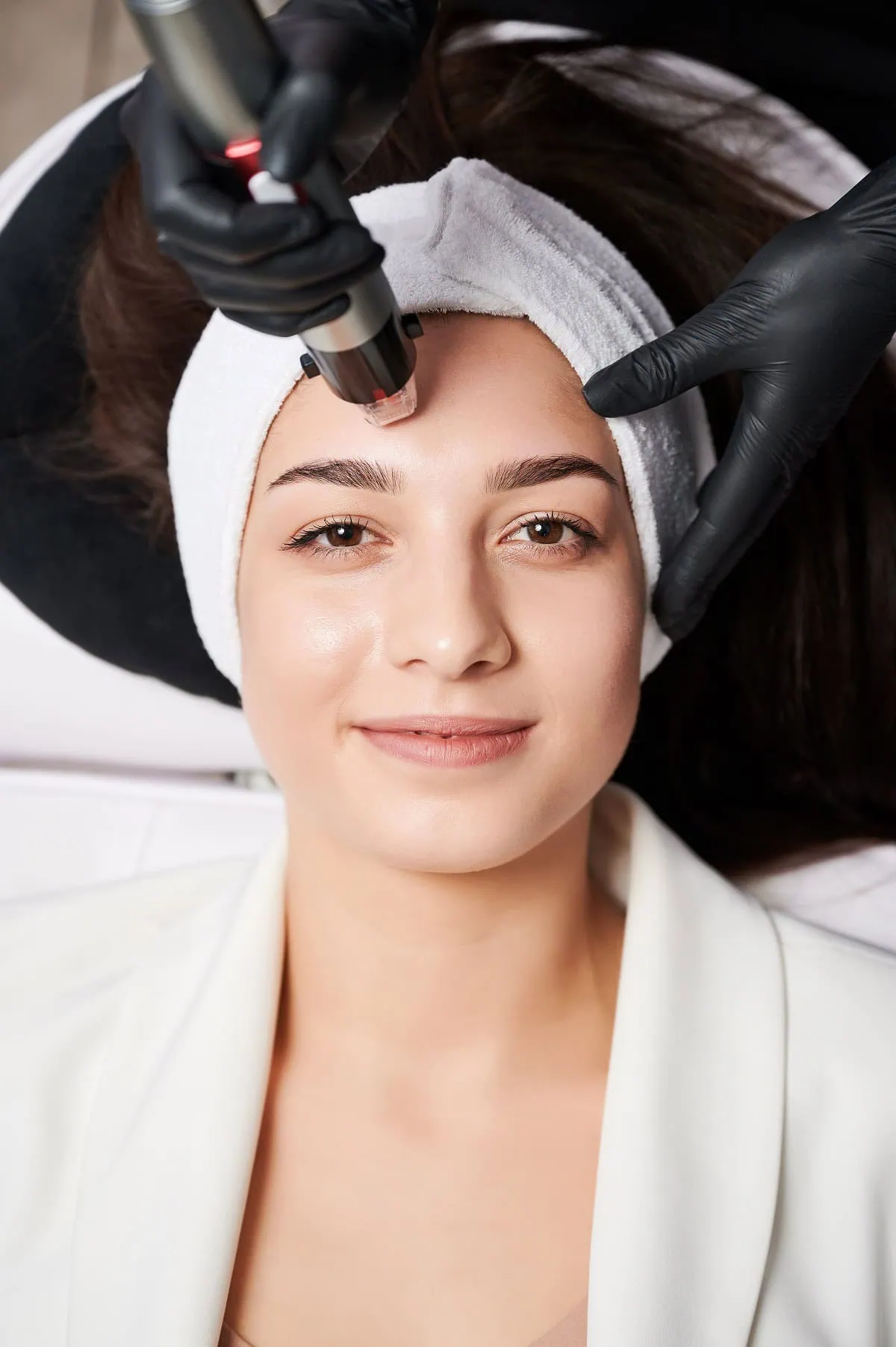 Microneedling facial treatment being performed in a spa setting.