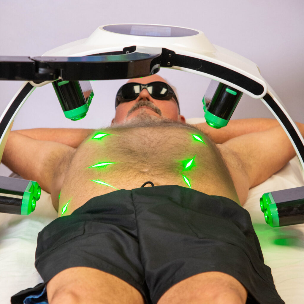 Emerald Body Sculpting procedure on a male patient in black shorts.