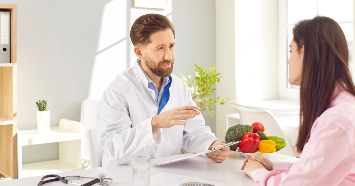 Healthcare professional discussing a personalized weight loss program in Oklahoma City, OK with a woman, with fresh vegetables and a measuring tape.