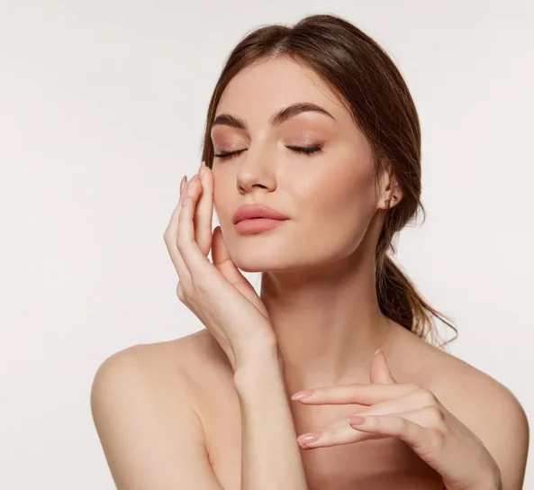 Woman touching her face after skin rejuvenation facial.