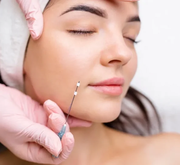 Medical aesthetician applying HydraFacial treatment to woman's face.