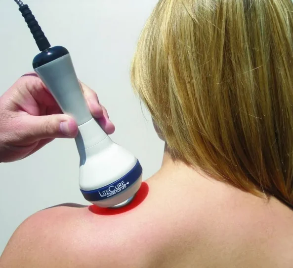 Aesthetic professional using body contouring device on shoulder.