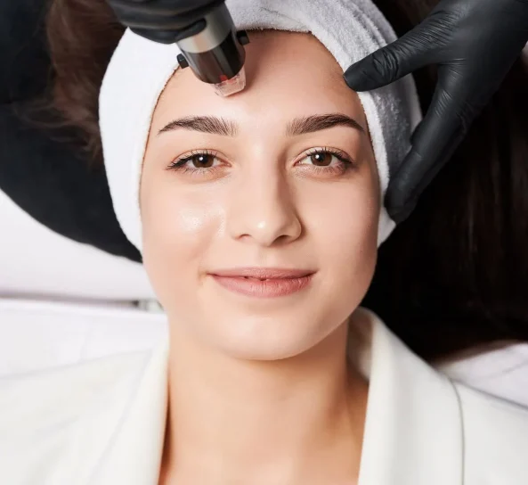 Microneedling facial treatment being performed in a spa setting.