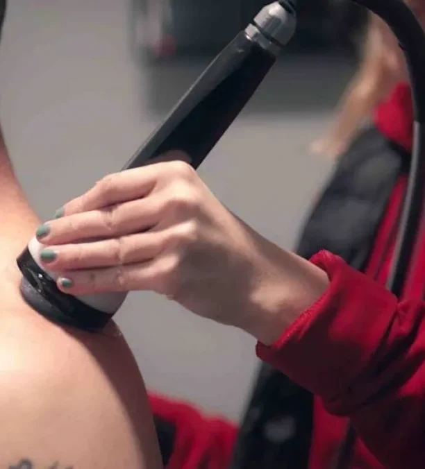 Technician performing cavitation fat reduction on client's back.